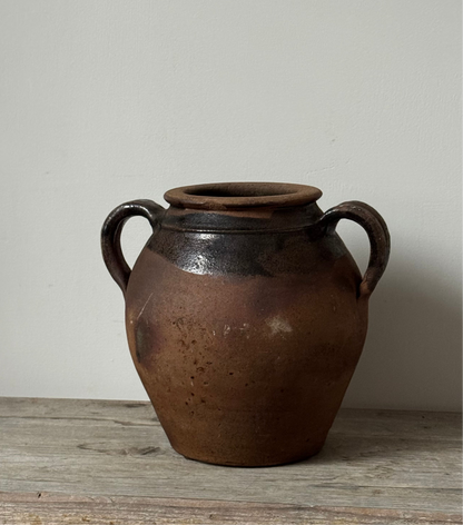 A rustic French Vintage pot with two side handles, featuring a dark brown and black glaze on the upper half and a matte earthy brown finish on the lower half.